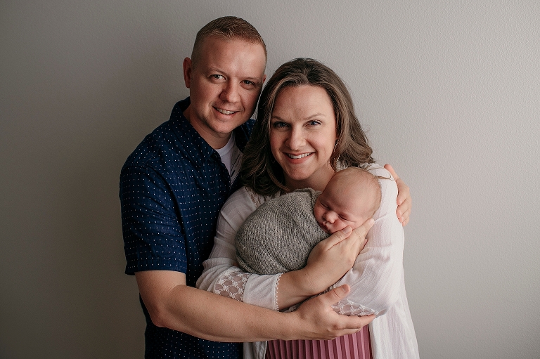 parents hold baby boy during classic newborn portraits