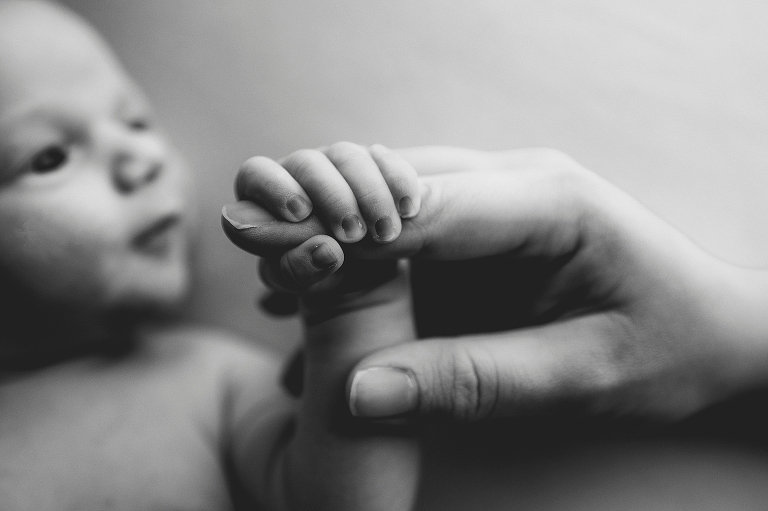 newborn baby boy holds mom's hand during AK newborn session
