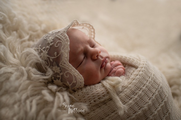 Newborn wrapped in white with lace hat during Alaska Classic Newborn Portrait Session