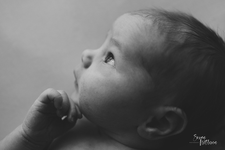 Newborn with eyes open looking up 