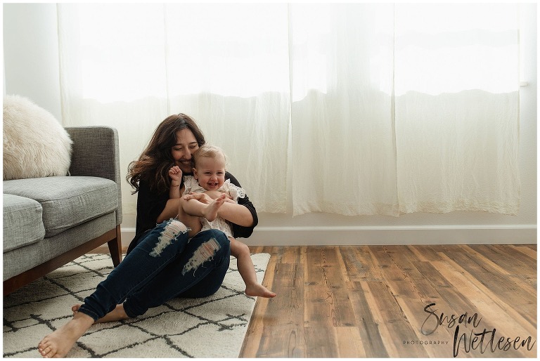 Mom holds baby girl close and snuggles her