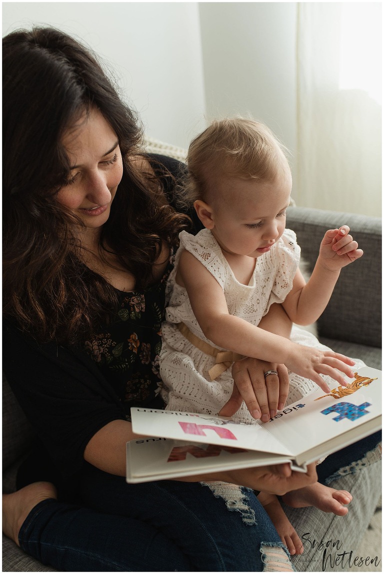 Mom and baby girl read book together